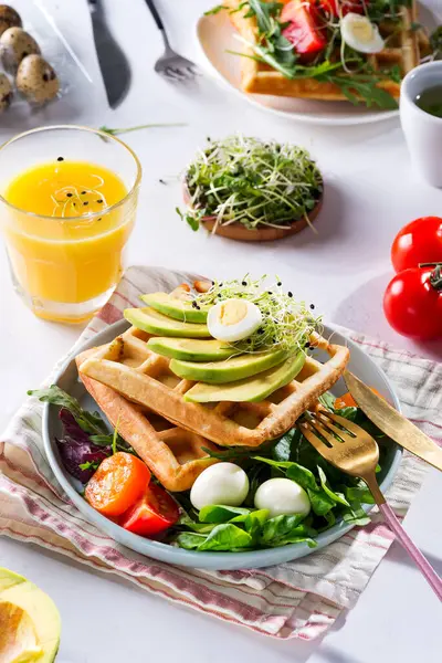 Ώρα για πρωινό. Βάφλα με σαλάτα, αυγό, χυμό και αβοκάντο για πρωινό. Άποψη από ψηλά. — Φωτογραφία Αρχείου