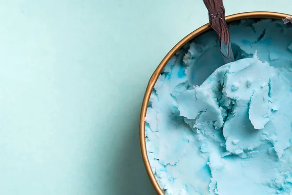 Helado natural casero azul fresco en un tazón con cuchara sobre un fondo azul claro . —  Fotos de Stock