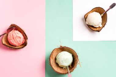 Duoton pastel arka planda kağıt çarşaflı taze doğal renkli dondurmayla hindistan cevizi kabukları.