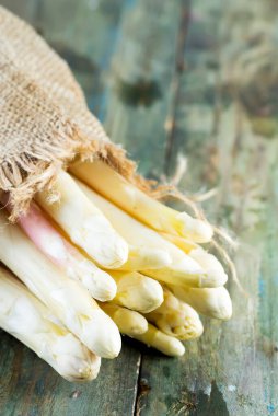 Tahta arka planda taze koparılmış doğal organik kuşkonmaz sebzeleri..