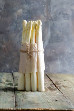 Tahta arka planda taze koparılmış doğal organik kuşkonmaz sebzeleri..