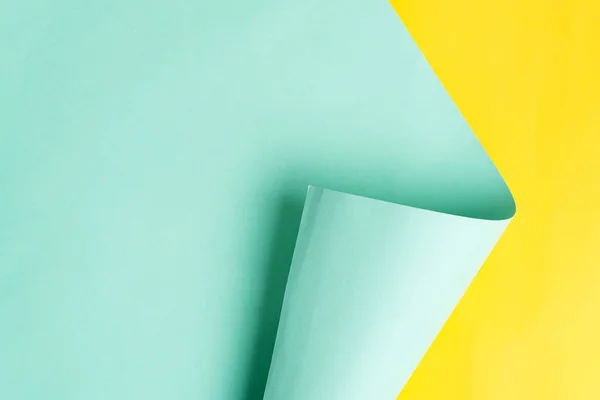 Hoja de papel simulada de color turquesa pastel curvada sobre un fondo amarillo. Diseño de papelería creativa . — Foto de Stock
