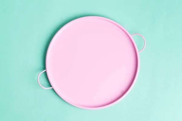Placa de cerámica rosa redonda vacía para representar alimentos recién cocinados sobre un fondo turquesa claro . — Foto de Stock
