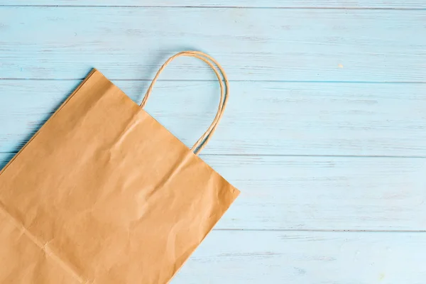 可重复使用的绿色纸袋，用于购买木制浅蓝色背景的新鲜天然产品. — 图库照片