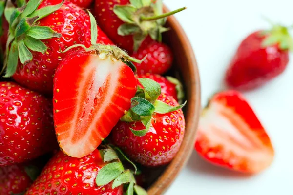 Nahaufnahme von frisch gepflückten reifen natürlichen Bio-Erdbeerfrüchten in einer hölzernen Schüssel auf weißem Hintergrund. — Stockfoto