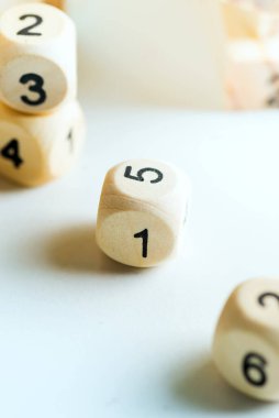 Açık gri zemin üzerinde rakamlar olan tahta küpler. Zar oyunu konsepti.
