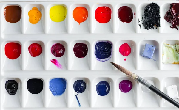 Kunststoffpalette mit bunten Farben auf hellgrauem Backgrund. — Stockfoto