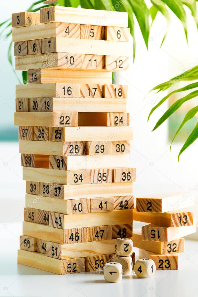 Piramyd from wooden blocks with numbers on a white background. Jenga game for earning and developing.