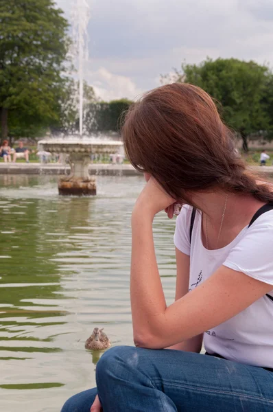 池の上に座っている若い女性 — ストック写真