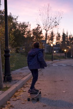 Gün batımında kaykay ile oynamak