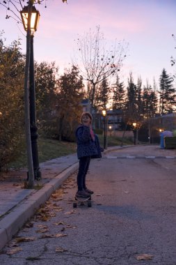 Gün batımında kaykay sokakta oynarken kızlar