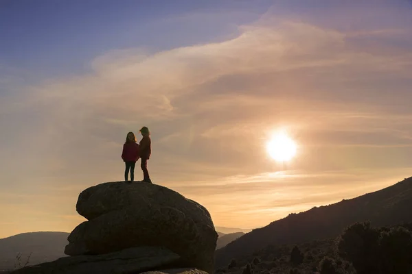 Mädchen spielen bei Sonnenuntergang auf dem Gipfel des Berges — Stockfoto