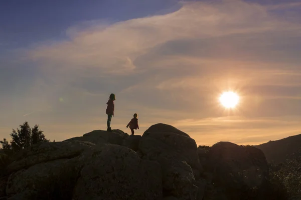 Dziewczyn gry o zachodzie słońca na szczycie góry — Zdjęcie stockowe