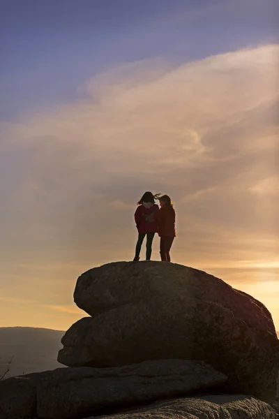 Girls playing at sunset on top of the mountain — Stock Photo, Image