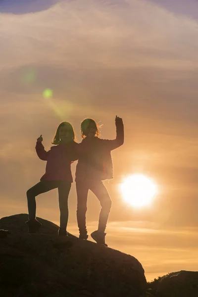 Meninas brincando ao pôr do sol no topo da montanha — Fotografia de Stock