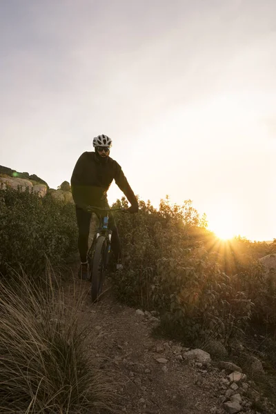 Ciclista en la montaña al atardecer — Foto de Stock