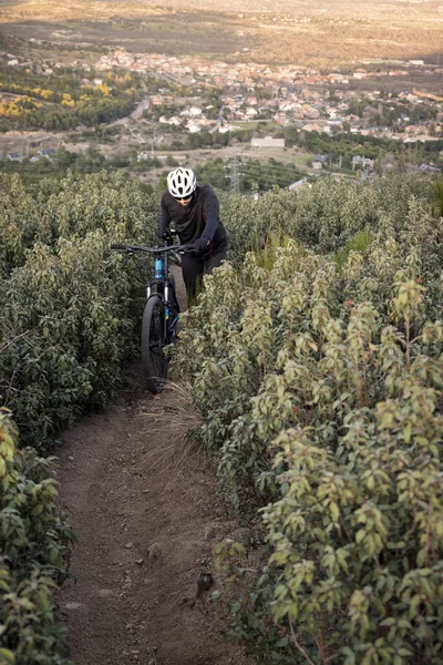 Hombre ciclista con su bicicleta de montaña escalando una roca a pie . — Foto de Stock