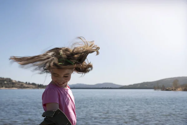 Adorable niña mirando el lago en un soleado día de primavera — Foto de Stock