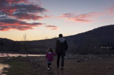 Günbatımı zamanı gölde, baba ve kızı walhing. Kavramı 