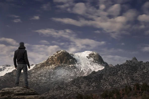 L'uomo contempla gli ultimi raggi del sole sulla montagna innevata — Foto Stock