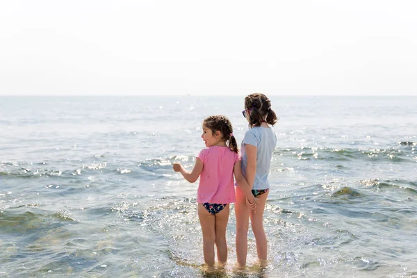 Sisters playing on the beach and holding hands. — Stock Photo, Image