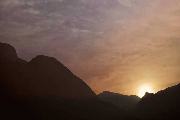 Siluetas de las colinas de montaña al atardecer. cascada de montaña —  Fotos de Stock