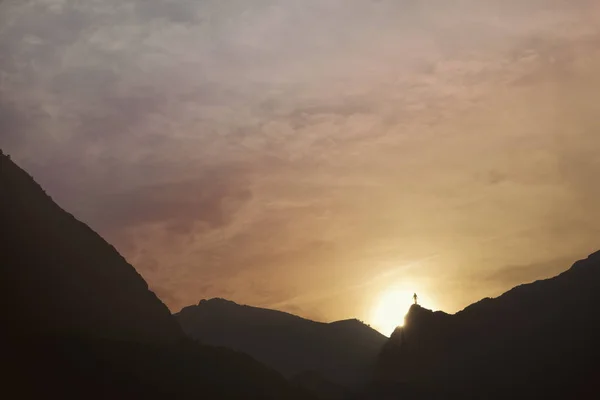 Silueta del hombre en la cima de la montaña al atardecer. Montaña —  Fotos de Stock