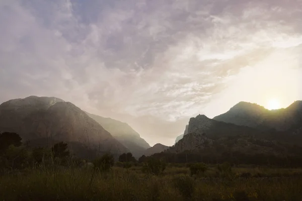 Siluetas de las colinas de montaña al atardecer. cascada de montaña —  Fotos de Stock