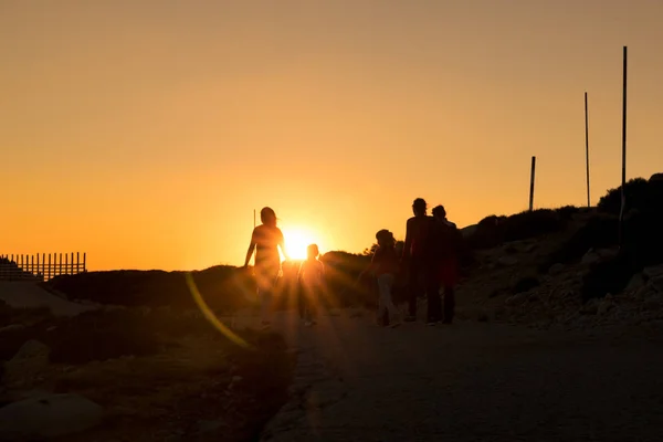 Silhouetten von Wanderern genießen die Aussicht auf den Sonnenuntergang vom Gipfel eines Berges — Stockfoto