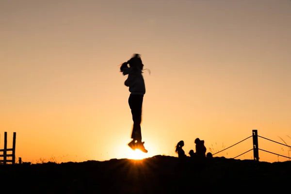 Sziluettek túrázók élvezi a naplemente kilátás a tetején egy kalandos utazás a hegyen — Stock Fotó