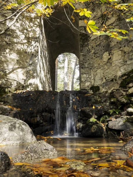 Cachoeira sob a ponte no rio da montanha no outono. Muito tempo. — Fotografia de Stock