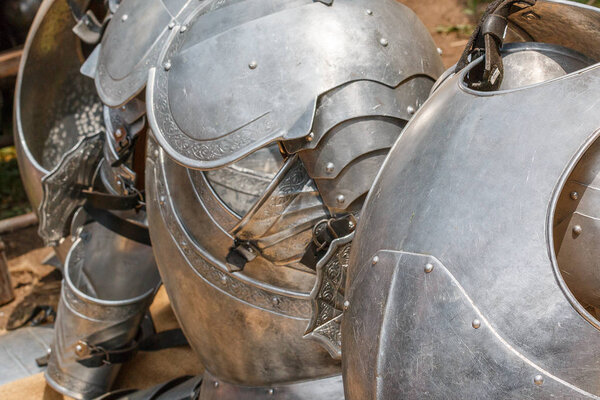 Photo shows close-up of metal knight armor piece during a day.