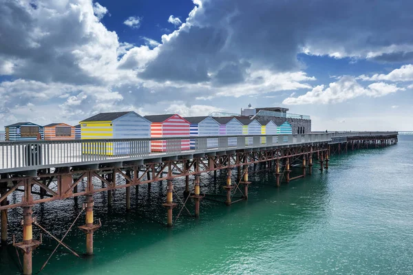 Hastings iskelesi ile renkli plaj kulübe — Stok fotoğraf