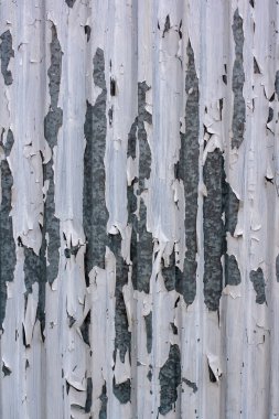 Galvanize metalin üzerindeki beyaz boyanın dokusu soyulmuş. Boya parça parça asılır ve düşer. Çatlaklar.