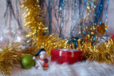 Noel kartında bir kardan adam ve şenlik süsleri. Noel süsleri ve kırmızı hediye kutusu. Önplanda seçmeli odak.