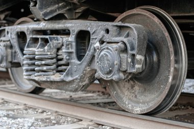 Raylı bir yük vagonunun tekerleği. Yaylı tekerlek sistemi. En yakın tekere odaklan.