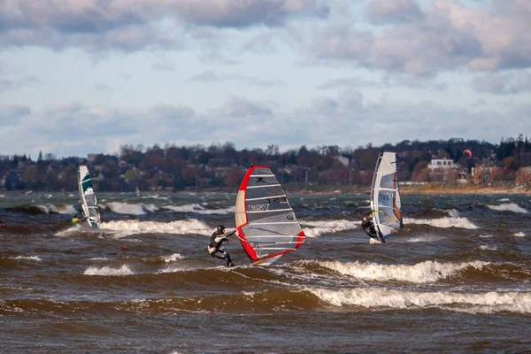 Tallinn, Estland - 18 oktober 2008: Windsurfers rijden op planken met een zeil op de golven op zee in een harde wind. — Stockfoto