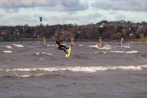 Tallinn, Estland - 18 oktober 2008: Kitesurfer hoppar högt över havet, gör tricks med studsande i blåst. — Stockfoto
