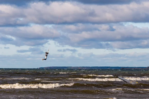 Tallinn, Estland - 18 oktober 2008: Kitesurfer springt met een zeil hoog boven de golven, vliegt over zee. — Stockfoto