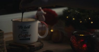 Sıcak bir Noel atmosferinde kahve karıştıran bir kadın..