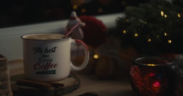 女性の手は居心地の良いクリスマスの雰囲気の中で飲料にわらを挿入 — ストック動画