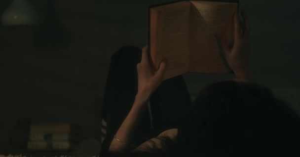 Mladá Žena Čte Knihu Matně Osvětlené Místnosti Přes Rameno Přes — Stock video