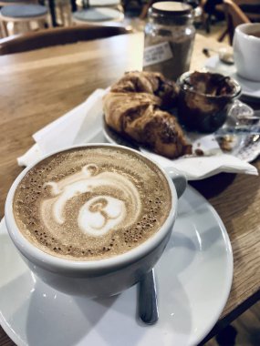 Bir fincan kapuçino ve kruvasan.