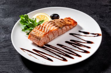 Beyaz tabak manzaralı haşlanmış somon balığı.