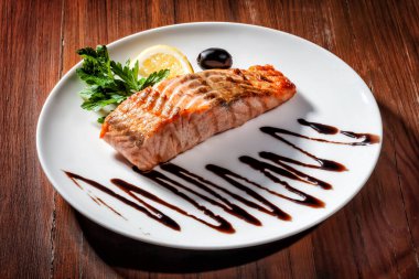 Beyaz tabak manzaralı haşlanmış somon balığı.