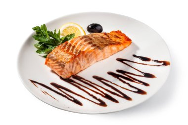 Beyaz tabak manzaralı haşlanmış somon balığı.