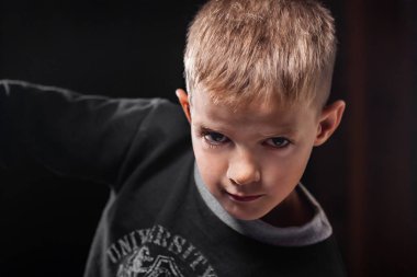 Siyah bir zemin üzerine yakışıklı bir çocuk portresi