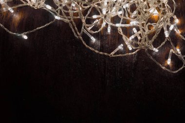 Siyah arka planda beyaz ışıkları olan çelenkler. tatil kavramı