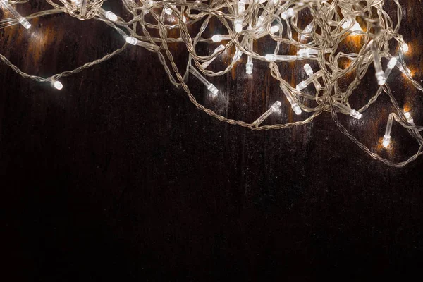 Siyah arka planda beyaz ışıkları olan çelenkler. tatil kavramı