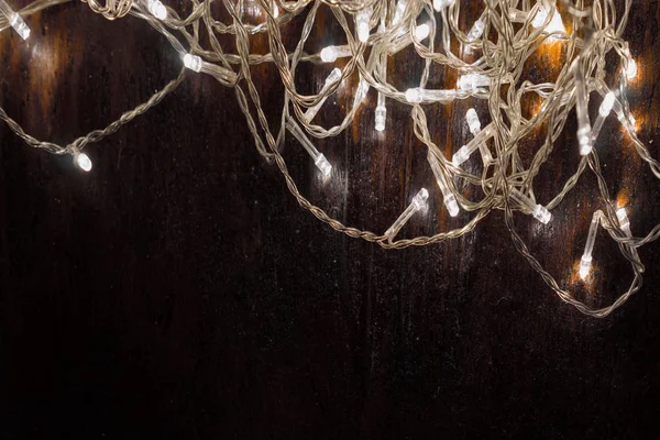 Siyah arka planda beyaz ışıkları olan çelenkler. tatil kavramı